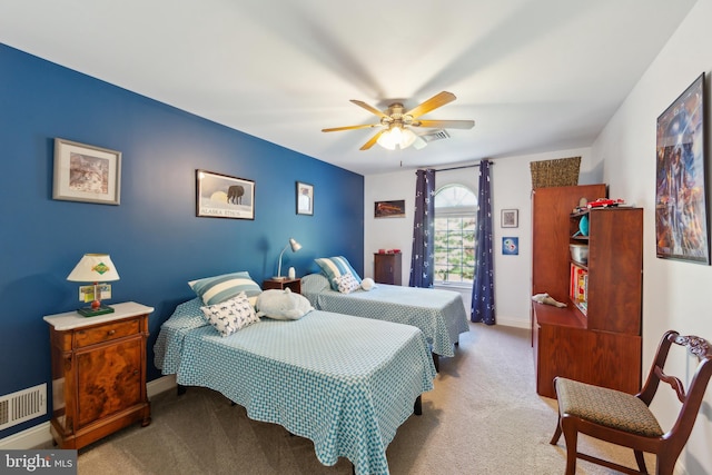 carpeted bedroom with a ceiling fan, baseboards, and visible vents