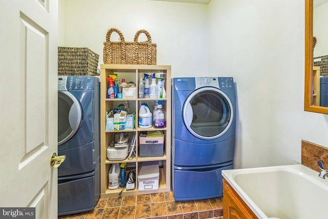 clothes washing area with laundry area, a sink, and washer / clothes dryer
