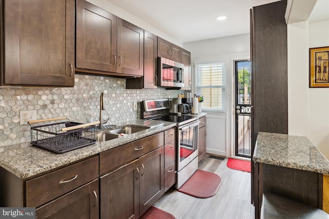 4311 Chatham Rd, Baltimore, MD 21207 - kitchen with appliances with stainless steel finishes, a sink, light wood-type flooring, backsplash, and dark brown cabinets