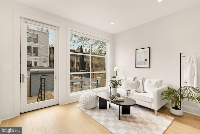 living area with recessed lighting, baseboards, and wood finished floors