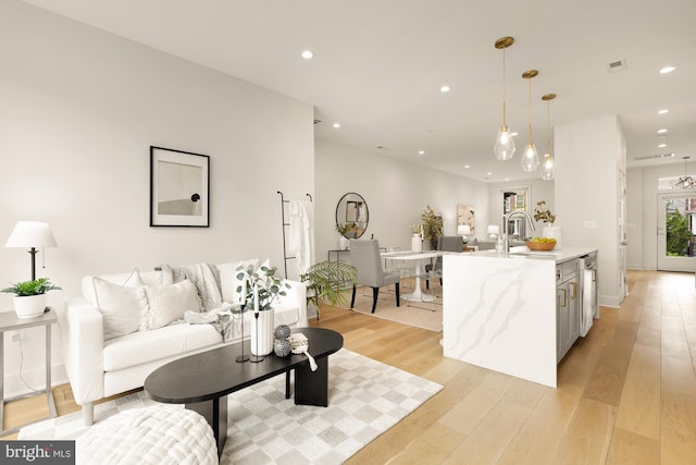 living room with recessed lighting, visible vents, and light wood-style flooring