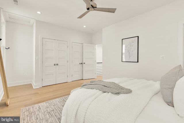 bedroom featuring recessed lighting, multiple closets, light wood-type flooring, and visible vents