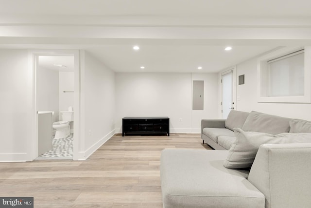 living area featuring recessed lighting, baseboards, electric panel, and light wood-type flooring