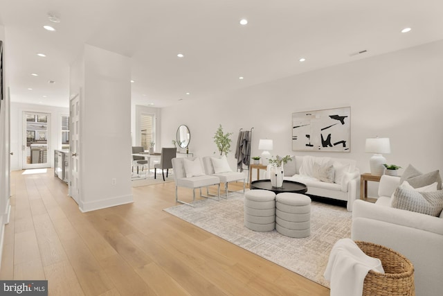 living area with light wood-style flooring, recessed lighting, baseboards, a healthy amount of sunlight, and visible vents