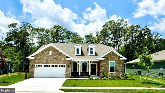 craftsman inspired home with an attached garage, driveway, a front lawn, and stone siding