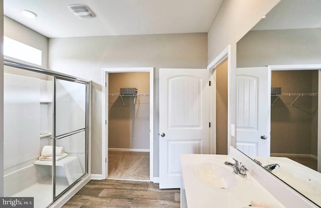 full bathroom featuring visible vents, a shower stall, wood finished floors, and vanity