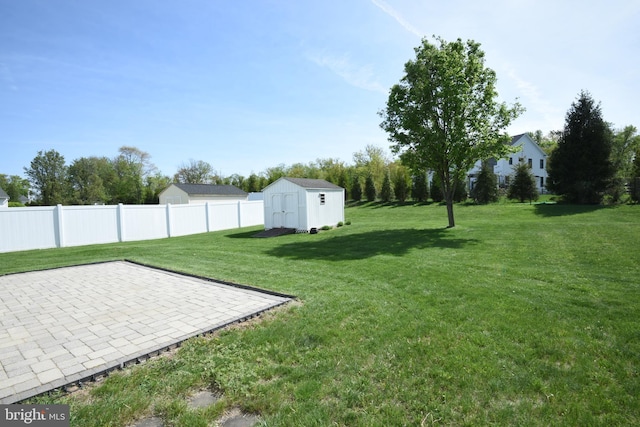 view of yard featuring an outbuilding, a shed, fence, and a patio