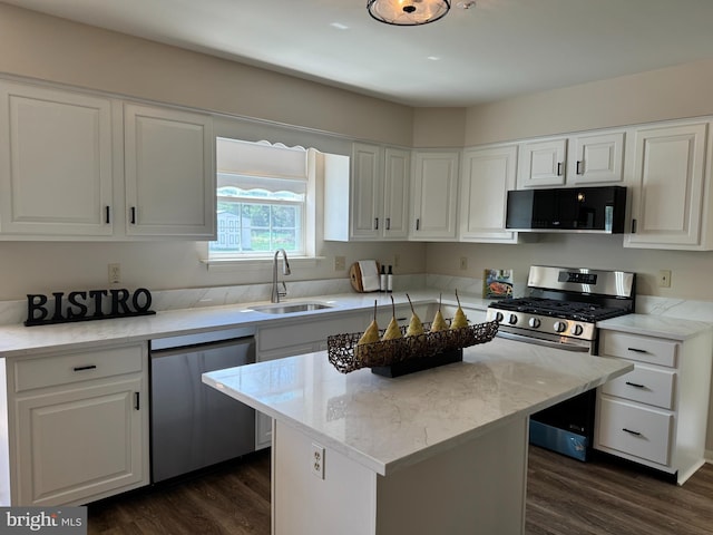 kitchen with stainless steel appliances, white cabinets, a sink, and dark wood-type flooring