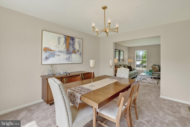 dining space featuring light carpet, a chandelier, and baseboards
