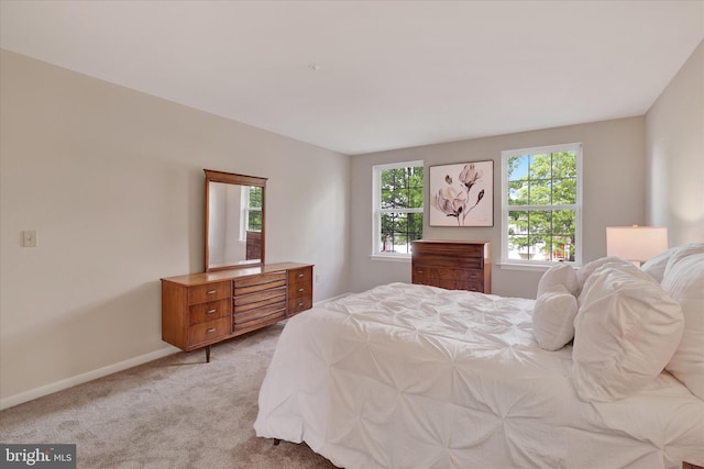 bedroom featuring light carpet and baseboards
