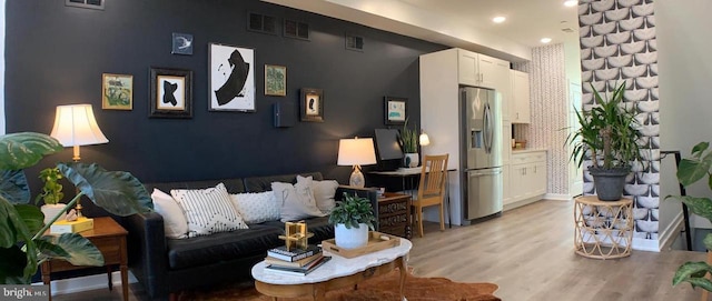 living area with light wood-style floors, recessed lighting, and visible vents