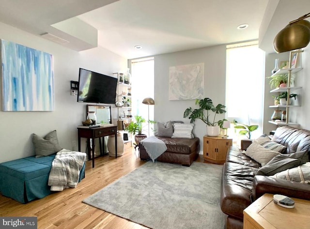 living area with a wealth of natural light, recessed lighting, wood finished floors, and visible vents