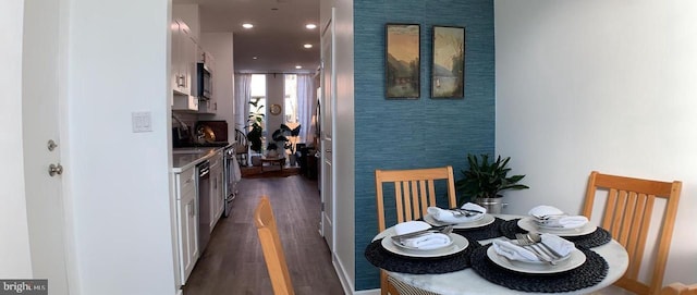 dining room with recessed lighting, an accent wall, and dark wood-type flooring