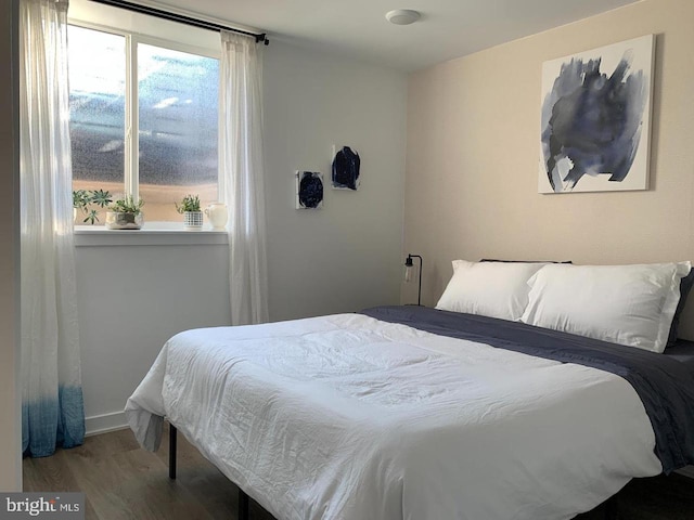 bedroom featuring baseboards and wood finished floors