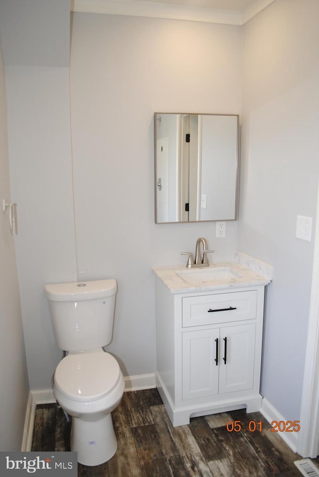 816 S Beaver St, York, PA 17403 - half bathroom featuring wood finished floors, baseboards, vanity, and toilet