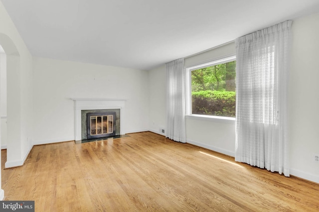 1529 Red Oak Dr, Silver Spring, MD 20910 - unfurnished living room with a fireplace with flush hearth, light wood finished floors, arched walkways, and baseboards