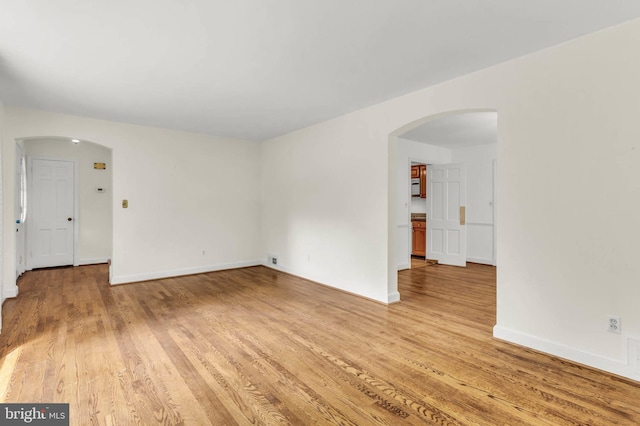 1529 Red Oak Dr, Silver Spring, MD 20910 - empty room featuring arched walkways, light wood-style flooring, and baseboards