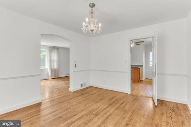 1529 Red Oak Dr, Silver Spring, MD 20910 - spare room featuring arched walkways, light wood finished floors, baseboards, a chandelier, and ceiling fan