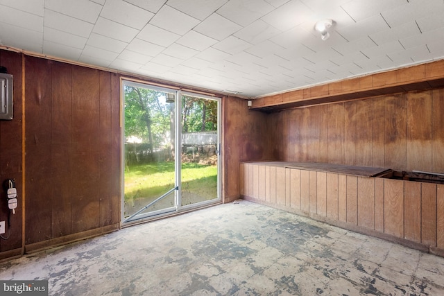 unfurnished room featuring wooden walls