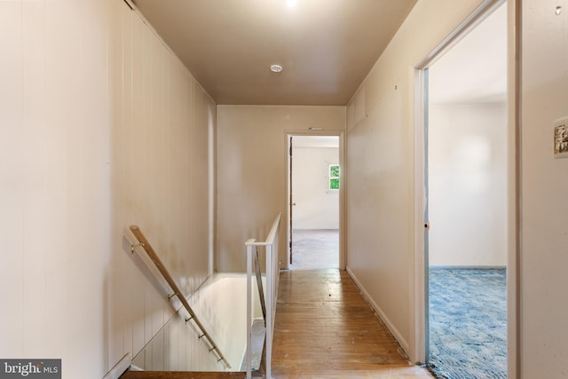 hallway with an upstairs landing and light wood finished floors