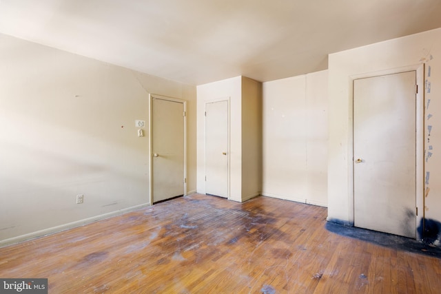 empty room featuring baseboards and hardwood / wood-style flooring