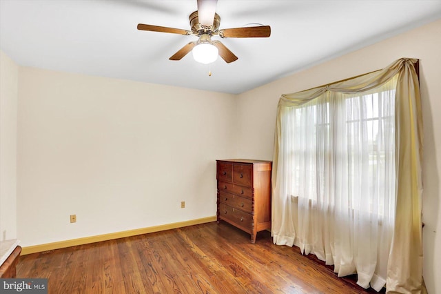 unfurnished room with baseboards, ceiling fan, and wood finished floors