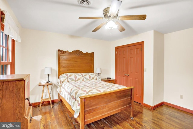 bedroom featuring visible vents, baseboards, wood finished floors, and a closet