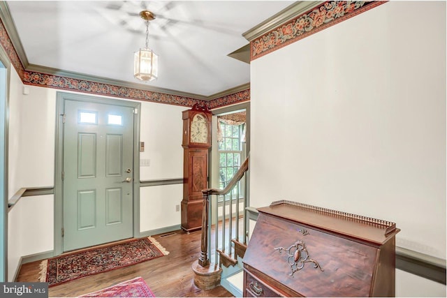entrance foyer with crown molding, plenty of natural light, wood finished floors, and stairway