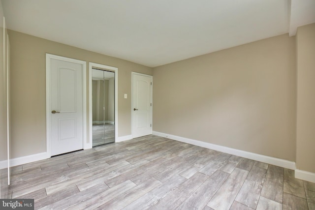 2030 N Adams St N Unit 507, Arlington, VA 22201 - unfurnished bedroom with light wood finished floors, a closet, and baseboards