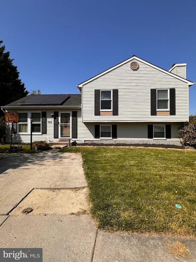 702 Rainbow Ct, Edgewood, MD 21040 - tri-level home featuring a chimney, a front yard, and solar panels
