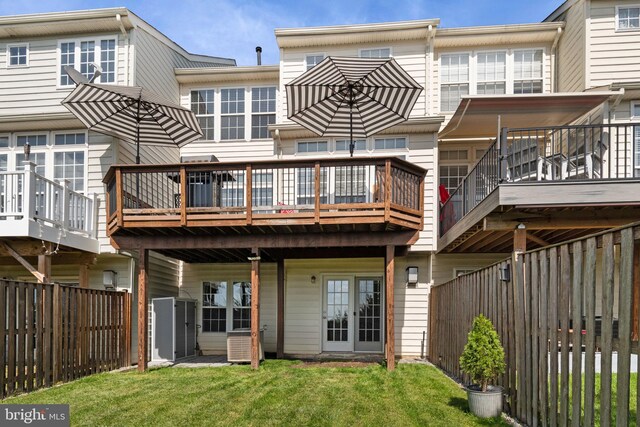 rear view of property with a lawn, a fenced backyard, and a wooden deck