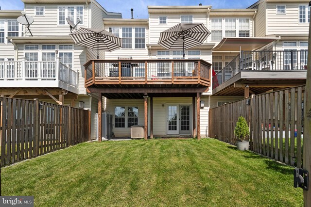 rear view of property featuring a lawn and a fenced backyard