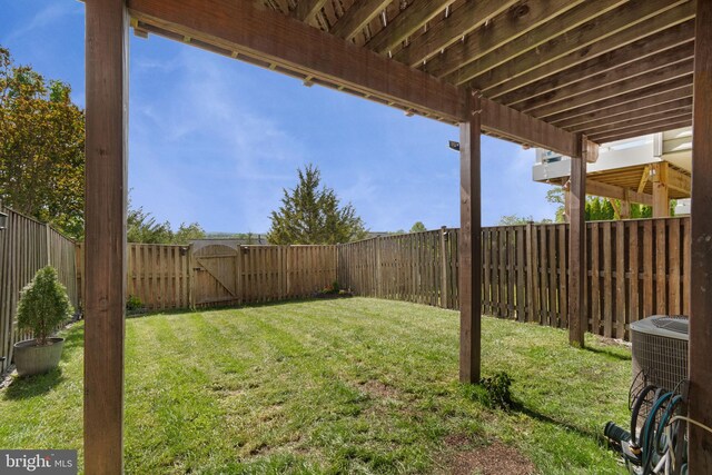 view of yard with a fenced backyard, a gate, and cooling unit