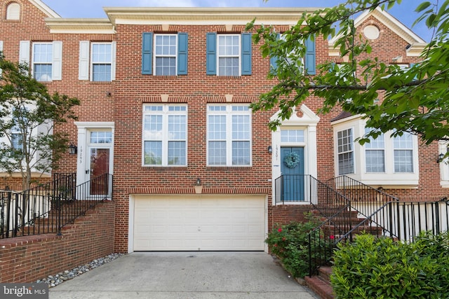 view of front of home featuring a garage, driveway, and brick siding