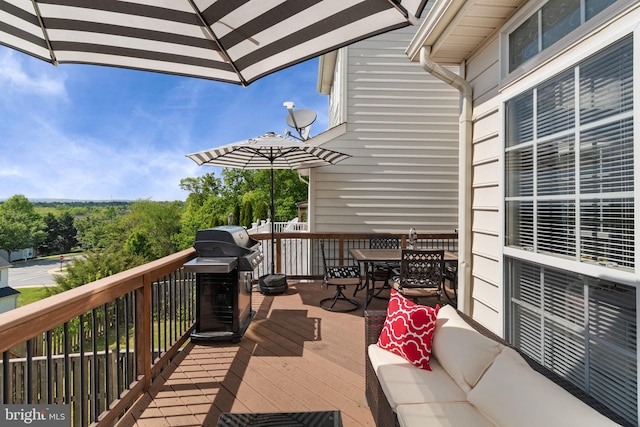 wooden terrace featuring outdoor dining space and grilling area