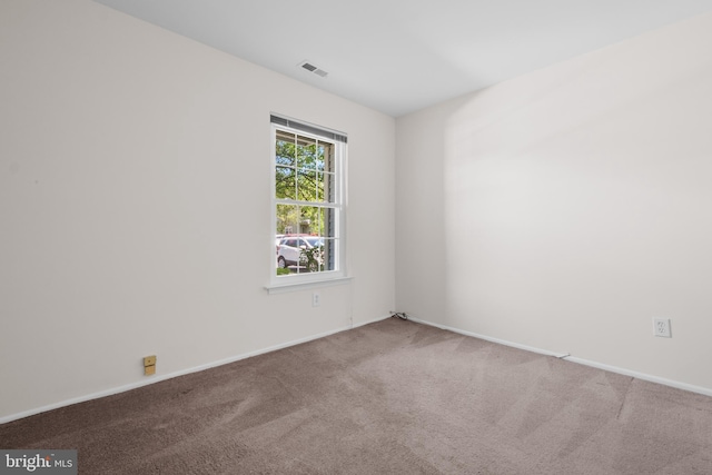 unfurnished room with baseboards, carpet flooring, and visible vents