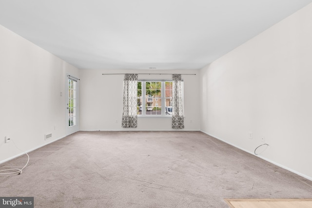 unfurnished room featuring carpet flooring and baseboards