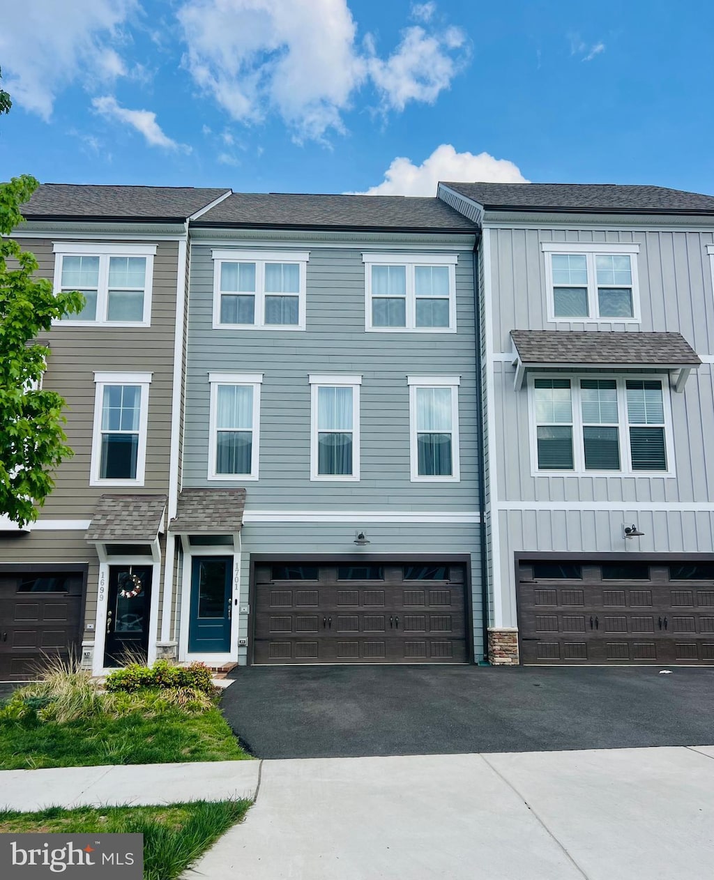 townhome / multi-family property with a garage, board and batten siding, and driveway