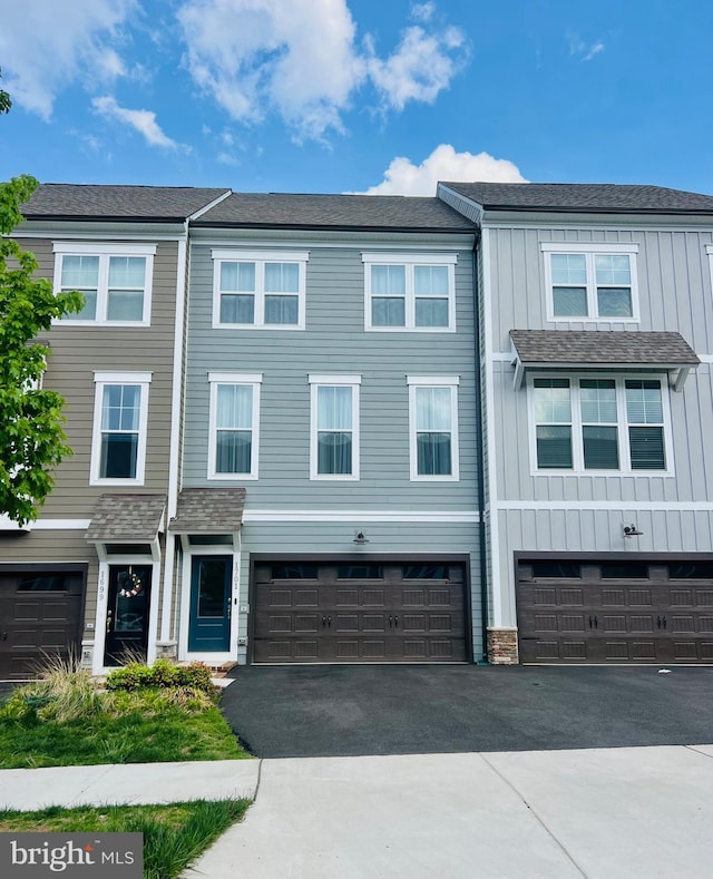 townhome / multi-family property with a garage, board and batten siding, and driveway