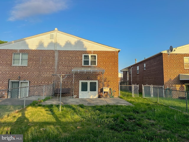 rear view of house with fence, a lawn, a patio area, and brick siding