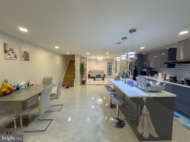 kitchen featuring recessed lighting, a kitchen breakfast bar, modern cabinets, and wall chimney exhaust hood