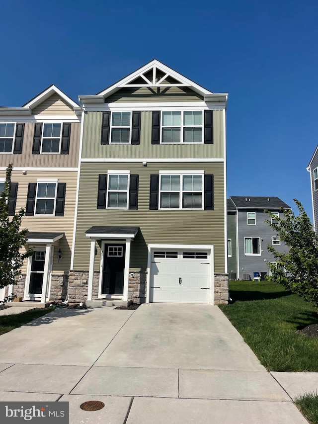 multi unit property with concrete driveway, an attached garage, board and batten siding, and stone siding