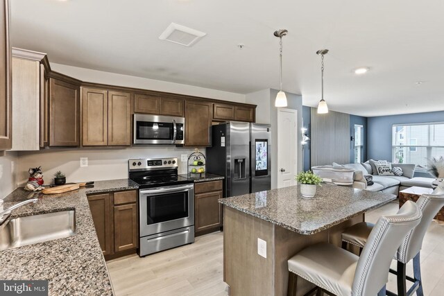 209 Sheridan St, Taneytown, MD 21787 - kitchen featuring appliances with stainless steel finishes, a sink, open floor plan, a breakfast bar area, and stone counters