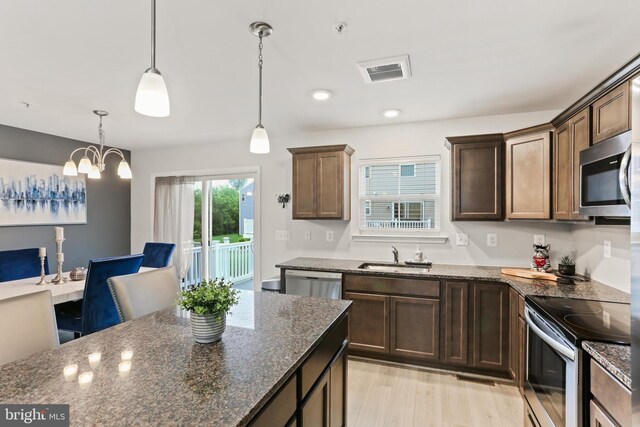 209 Sheridan St, Taneytown, MD 21787 - kitchen featuring appliances with stainless steel finishes, a sink, dark stone countertops, pendant lighting, and dark brown cabinets