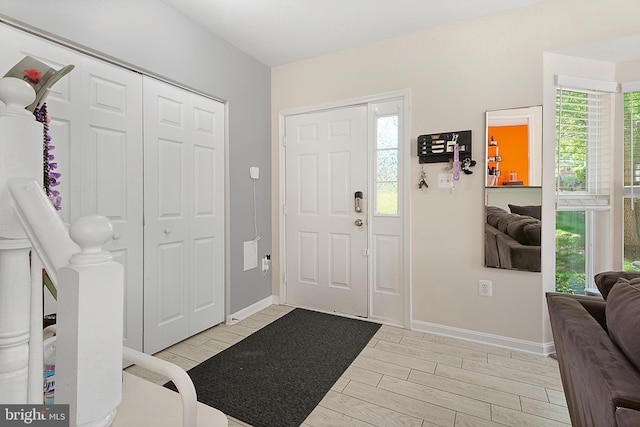foyer entrance with baseboards and wood tiled floor