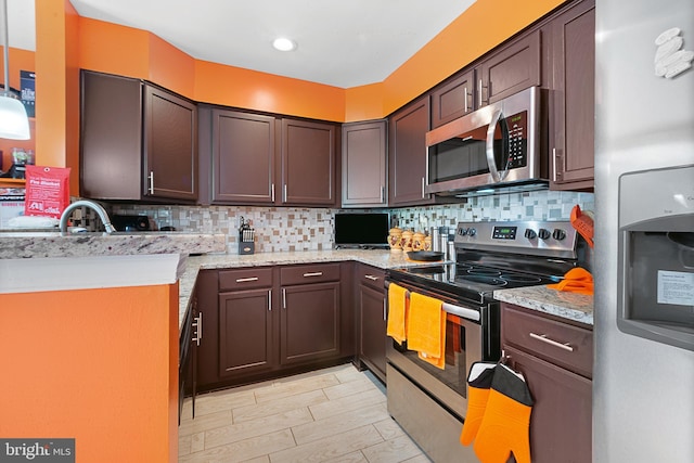 kitchen featuring stainless steel appliances, decorative backsplash, light stone counters, and dark brown cabinets