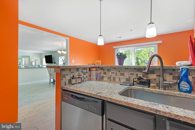 kitchen featuring a sink, stainless steel dishwasher, light stone counters, baseboards, and tasteful backsplash