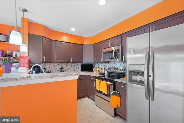 kitchen with stainless steel appliances, tasteful backsplash, decorative light fixtures, light wood finished floors, and light stone countertops