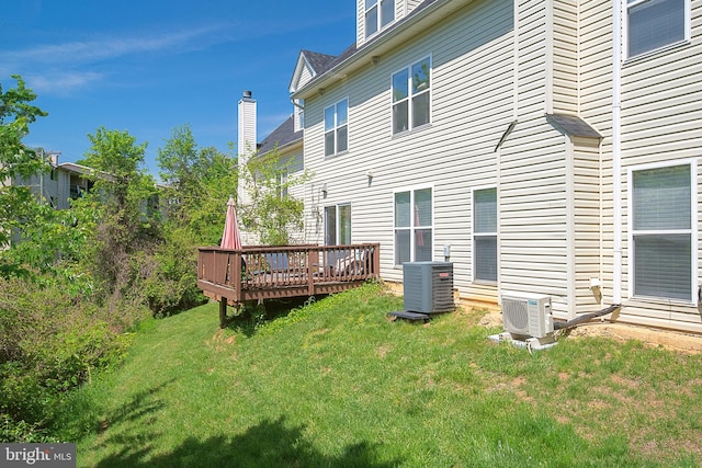 back of property featuring a chimney, a lawn, ac unit, central air condition unit, and a deck