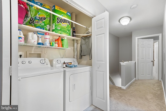 clothes washing area featuring washer and dryer, laundry area, and light colored carpet